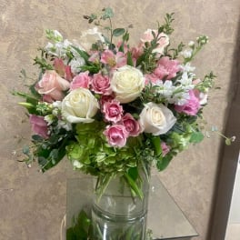 Pink and white rose bouquet in a clear glass vase