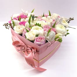 Pink heart-shaped box of white and pink roses with a ribbon bow