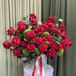 Large bouquet of red roses in a round box with ribbon
