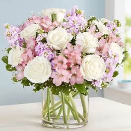 Pink and white flowers arranged in a clear glass vase