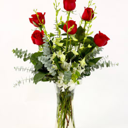 Red roses and white orchids in a clear glass vase