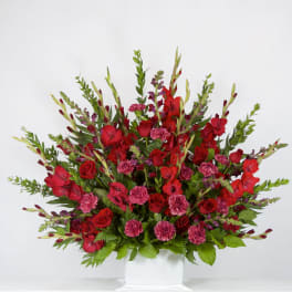 Red roses and pink carnations in a white vase