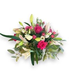 Pink roses and white lilies arranged in a glass vase
