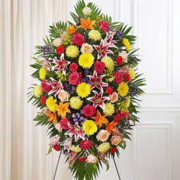 Large standing spray of mixed flowers in bright colors on an easel