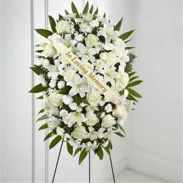 White sympathy standing spray with a ribbon on an easel