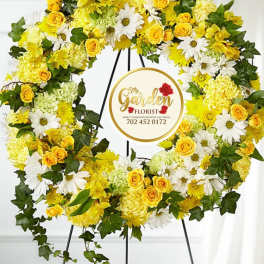 Yellow and white floral wreath on a black stand