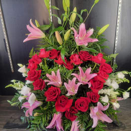 Large arrangement of red roses, pink lilies, and white flowers