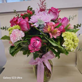 Pink and lavender bouquet in a glass vase with a ribbon