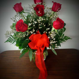 Bouquet of red roses with a red ribbon in a glass vase