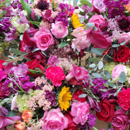 Assorted pink, red, purple, and yellow flowers arranged in a dense display