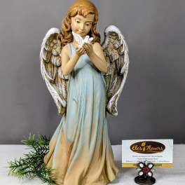 Angel figurine holding a white dove beside a florist card