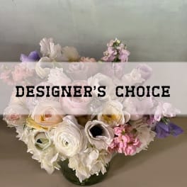 Pastel mixed flower arrangement in a glass vase with designer's choice text overlay