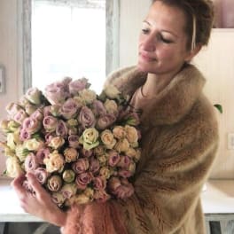 Woman holding a large bouquet of pastel roses