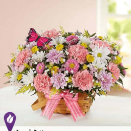 Pink and white mixed flower basket with a butterfly decoration