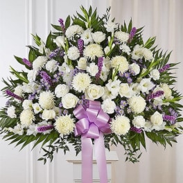 Large white floral standing spray with a lavender ribbon