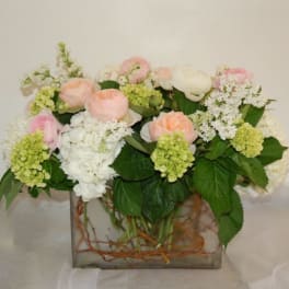 Pastel floral arrangement in a square glass vase