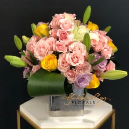 Pink and yellow rose bouquet in a square metal vase