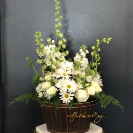 White flowers arranged in a brown basket with tall green stems