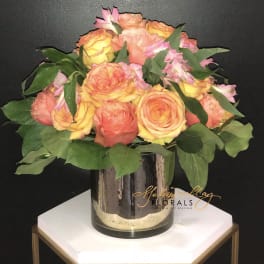 Bouquet of peach and yellow roses in a glass vase