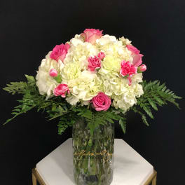 Pink and white floral arrangement in a clear glass vase