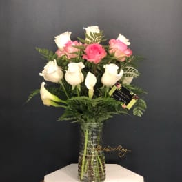 Pink and white roses arranged in a clear glass vase