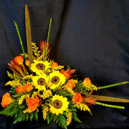 Orange roses and yellow sunflowers in a low floral arrangement