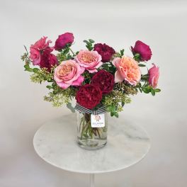 Pink and burgundy roses arranged in a clear glass vase