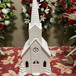 White church-shaped holiday decoration on a gingerbread tablecloth