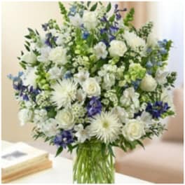 White and blue mixed flower bouquet in a glass vase