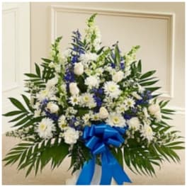 White and blue floral standing spray with a blue ribbon