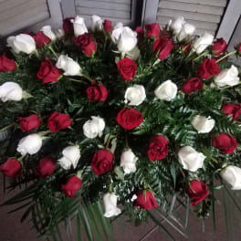 Arrangement of red and white roses with dense greenery