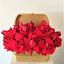 Red roses arranged in a gold gift box