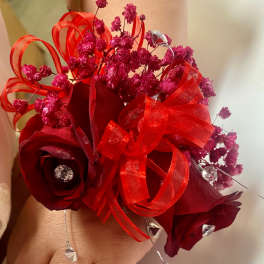 Small red rose bouquet with pink filler and ribbon loops