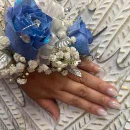 Blue rose wrist corsage with white baby's breath and silver ribbon