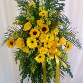 Tall yellow floral spray with roses and daisy blooms on a stand
