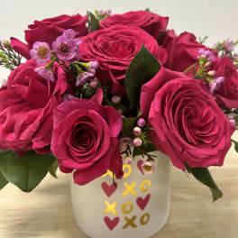 Hot pink roses with small pink blossoms in a white mug