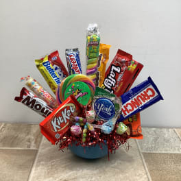 Candy bouquet in a blue bowl with assorted chocolate bars and lollipops