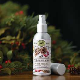 Bottle of white spruce scented room spray with a floral holiday background
