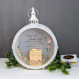 White memorial lantern with floral accents and a sympathy message