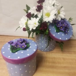 White daisies and purple carnations in a polka-dot box with matching lids