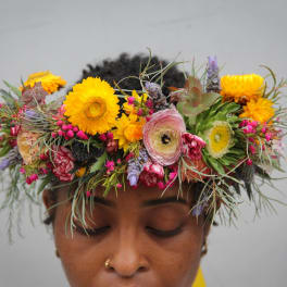 Person wearing a colorful flower crown with yellow and pink blooms