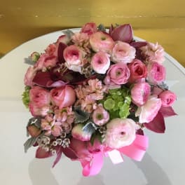 Pink and burgundy bouquet with a ribbon on a white table