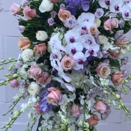 Large pastel bouquet with roses and orchids on a stand