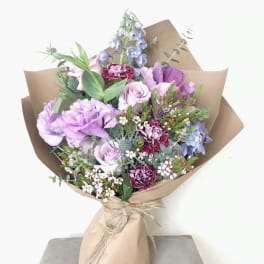 Lavender and pink mixed bouquet wrapped in brown paper