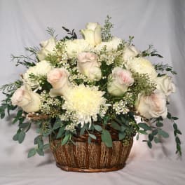 White and blush rose and mum basket arrangement with small white filler flowers