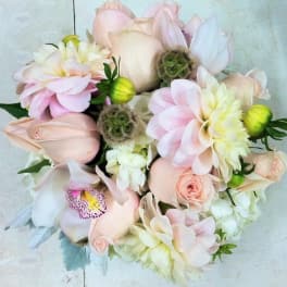 Soft pink and white bouquet with roses, orchids, and dahlias