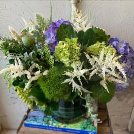 Purple hydrangeas and white astilbe in a glass vase