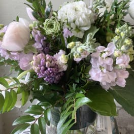 Pastel bouquet of white, pink, and purple flowers in a glass vase