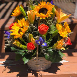 Basket arrangement with sunflowers, roses, and lilies