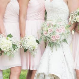Bridesmaids and bride holding pale pink and white bouquets